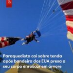 Paraquedista amarrado à bandeira gigante dos EUA se enrosca em árvore